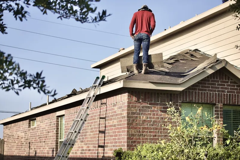Professional roofer working on a residential roof in Thomasdale